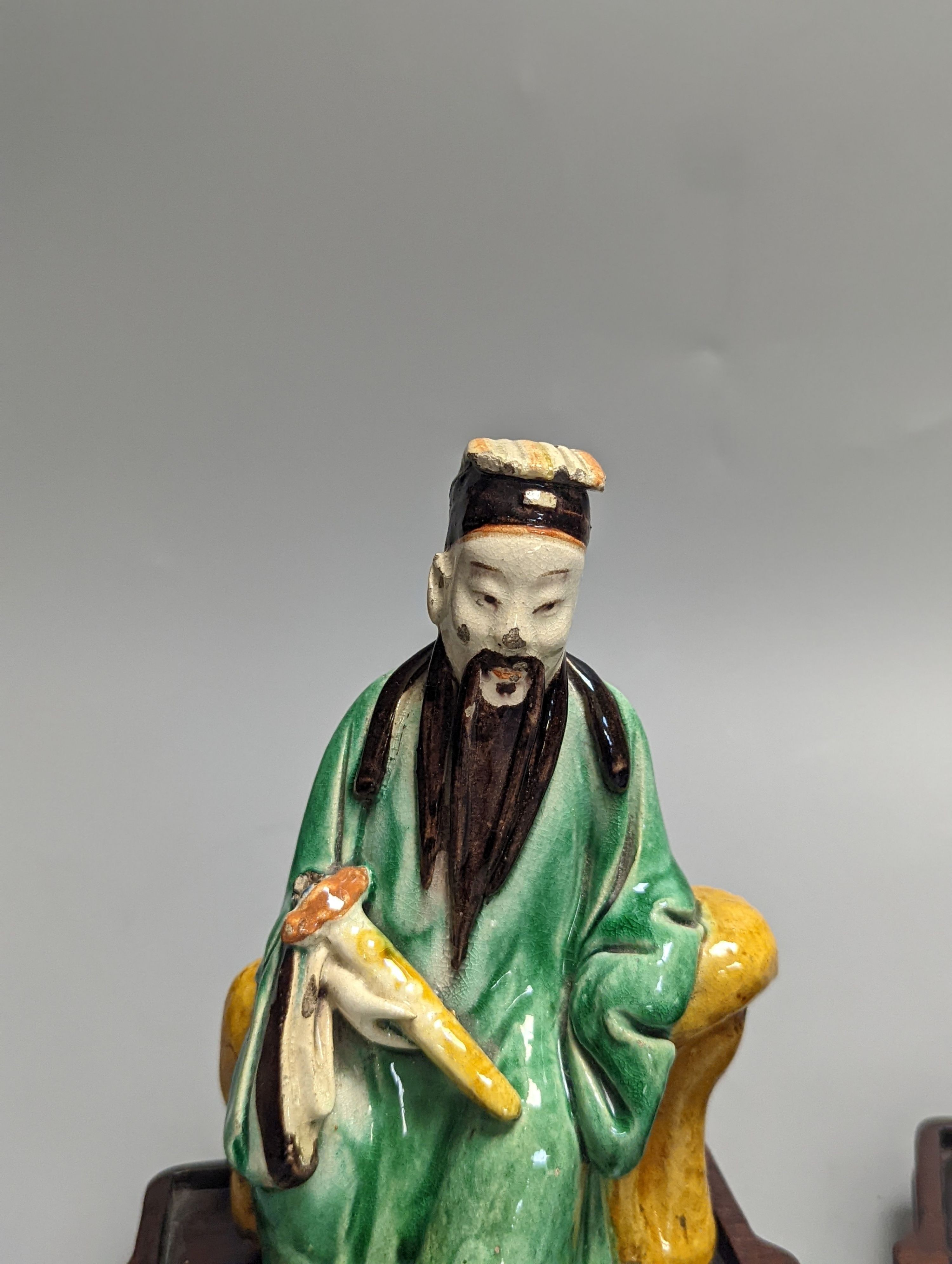 An 18th century Chinese sancai biscuit group of Guanyin with child and a 19th century Chinese sancai figure of Lu Dongbin, associated hardwood stands. 16cm